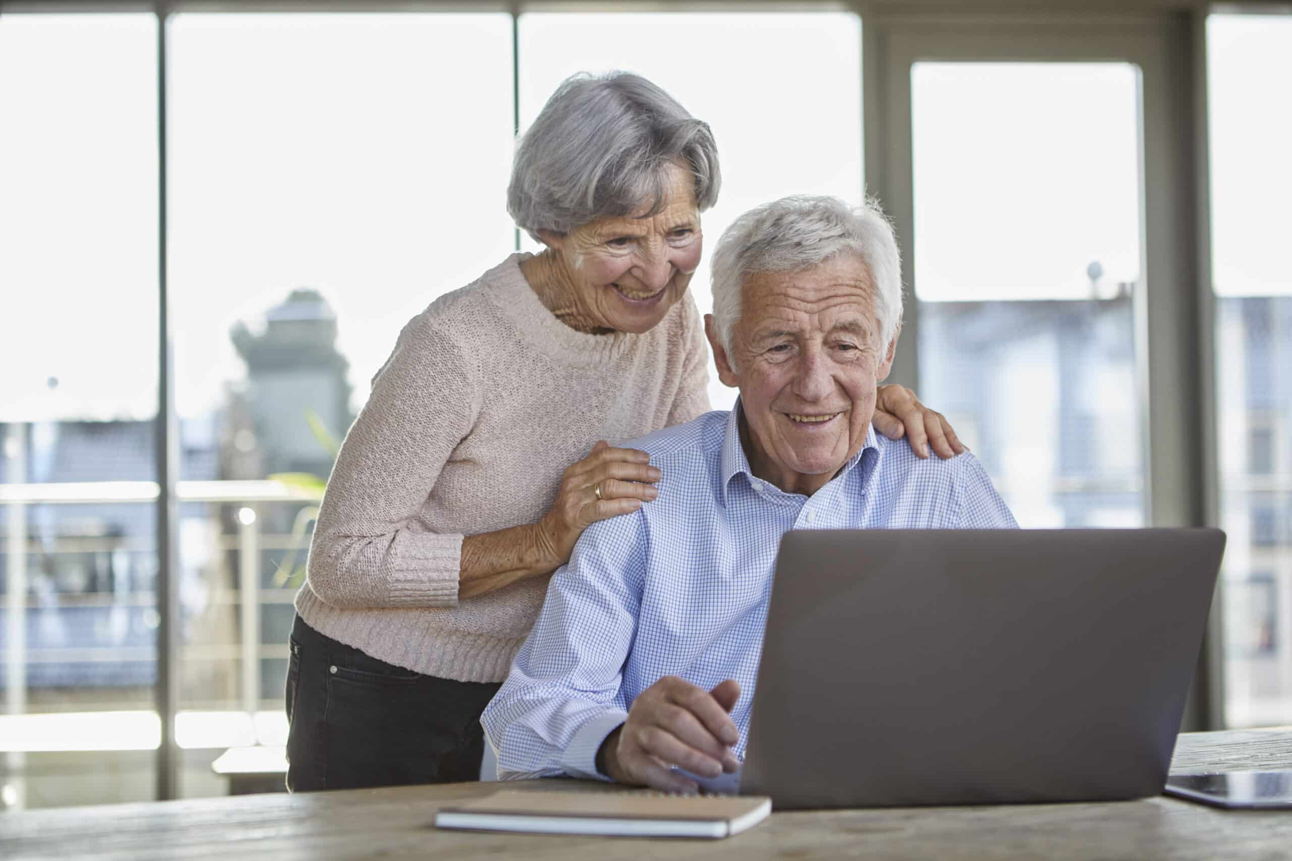 Portrait of smiling senior couple using laptop